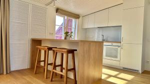 a kitchen with wooden stools and a counter top at City Center Appartment in Vilnius