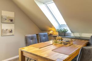 a dining room with a table and chairs and a window at Pier17 Appartement 6 in Borkum