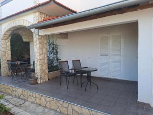 a patio with chairs and a table and a building at Guest house Renata 2 in Zadar