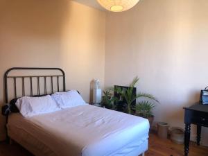 1 dormitorio con cama con sábanas blancas y piano en Le petit matelot, en Paimpol