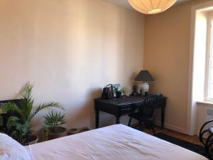 Un dormitorio con una cama y un escritorio con un piano. en Le petit matelot, en Paimpol