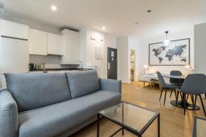Una sala de estar con un sofá y una mesa y una cocina. en Allo Apartments Santa María III Centro Loft, en Jerez de la Frontera