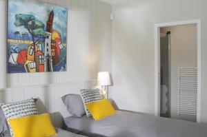 a bedroom with a couch and a painting on the wall at La villa aux oiseaux in Andernos-les-Bains +38 photos