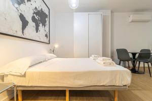Un dormitorio con una cama y una mesa y sillas. en Allo Apartments Santa María III Centro Loft, en Jerez de la Frontera