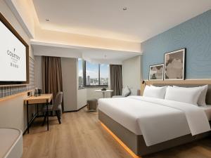 Postel nebo postele na pokoji v ubytování Country Inn & Suite by Radisson, Guangzhou Railway Station Xiaobei