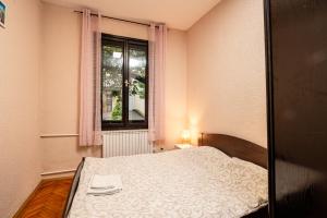 a small bedroom with a bed and a window at Cozy apartment in city center in Belgrade