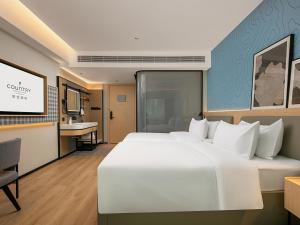 Postel nebo postele na pokoji v ubytování Country Inn & Suite by Radisson, Guangzhou Railway Station Xiaobei
