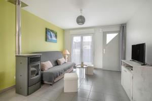 ein Wohnzimmer mit Sofa und Fernseher in der Unterkunft Maison de plain-pied - quartier calme pour six personnes in La Plaine-sur-Mer