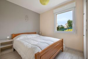 ein Schlafzimmer mit einem Bett und einem Fenster in der Unterkunft Maison de plain-pied - quartier calme pour six personnes in La Plaine-sur-Mer