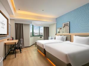 Postel nebo postele na pokoji v ubytování Country Inn & Suite by Radisson, Guangzhou Railway Station Xiaobei