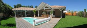 a backyard with a swimming pool and a house at La villa aux oiseaux in Andernos-les-Bains