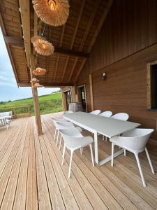 a white table and chairs on a wooden deck at Chalet du Hazard in Gerbépal