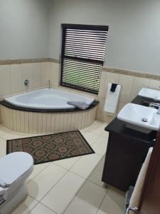a bathroom with a tub and a toilet and a sink at Zimbali Coastal Resort Yellowwood House in Ballito