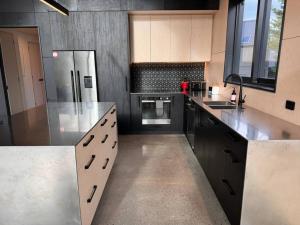a large kitchen with stainless steel appliances and black cabinets at Rifugio Castle Hill in Castle Hill