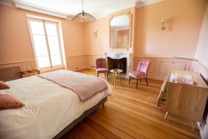 a bedroom with a bed and two chairs and a fireplace at LES FRENES EN PROVENCE-CHÂTEAU ZEN in Avignon