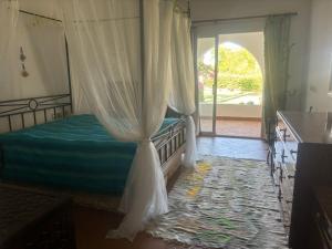 Villa Domina Coral Bay في شرم الشيخ: غرفة نوم بسرير مع مظلة