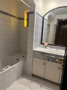 Villa Domina Coral Bay في شرم الشيخ: حمام مزود بحوض استحمام ومغسلة ومرآة