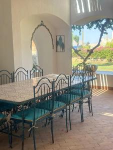 Villa Domina Coral Bay في شرم الشيخ: طاولة طعام مع كراسي وطاولة ونافذة