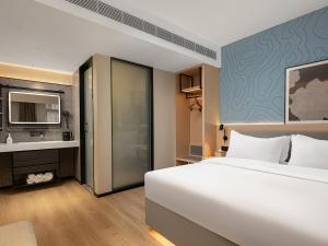 Postel nebo postele na pokoji v ubytování Country Inn & Suite by Radisson, Guangzhou Railway Station Xiaobei