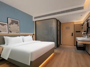 Postel nebo postele na pokoji v ubytování Country Inn & Suite by Radisson, Guangzhou Railway Station Xiaobei