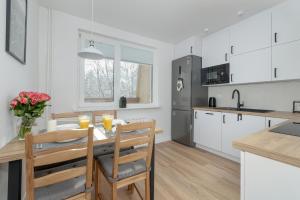 a kitchen and dining room with a table and chairs at Mountain Corner Apartment in Zakopane by Noclegi Renters in Zakopane