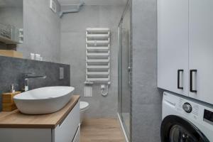a bathroom with a sink and a washing machine at Mountain Corner Apartment in Zakopane by Noclegi Renters in Zakopane