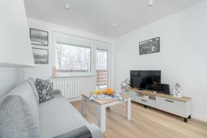 a living room with a couch and a tv and a table at Mountain Corner Apartment in Zakopane by Noclegi Renters in Zakopane +18 photos