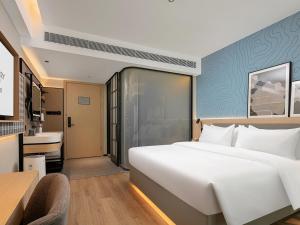 Postel nebo postele na pokoji v ubytování Country Inn & Suite by Radisson, Guangzhou Railway Station Xiaobei