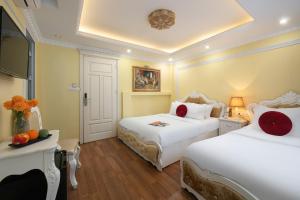 a hotel room with two beds and a television at Hanoi Oldtown Hotel in Hanoi