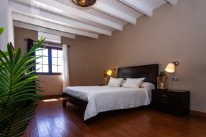 a bedroom with a bed with white sheets and a plant at Villa ConchaMar Oceanbeach in Playa Honda +65 photos