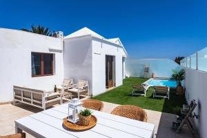 a white house with a patio and a swimming pool at Villa ConchaMar Oceanbeach in Playa Honda