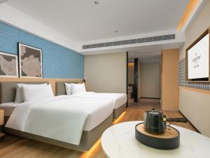 Postel nebo postele na pokoji v ubytování Country Inn & Suite by Radisson, Guangzhou Railway Station Xiaobei