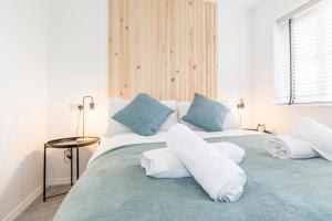 a bedroom with a large bed with white and blue pillows at Host & Stay - Polwell Road in Kibworth Harcourt