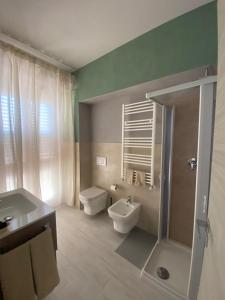 un bagno con wc, lavandino e doccia di La terrazza nel borgo a Tortora Altre 37 foto