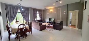 a living room with a table and a living room with a couch at Big Mama's House in Tanah Rata