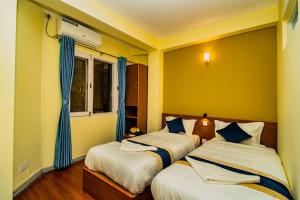 Una cama o camas en una habitación de Hotel Aashraya Home