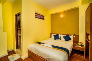 Una cama o camas en una habitación de Hotel Aashraya Home