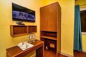 Una televisión o centro de entretenimiento en Hotel Aashraya Home