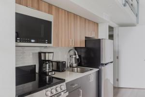 a kitchen with a sink and a refrigerator at Blueground Tacoma gym elevator lounge wd SEA-773 in Seattle