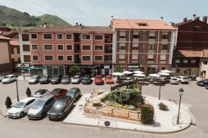 a parking lot with cars parked in front of a building at Mirando al sella in Arriondas