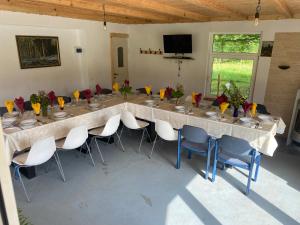 a long table in a room with chairs and flowers at Rosa&Vera in Ucea de Sus