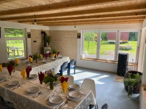 a dining room with a long table in a room with windows at Rosa&Vera in Ucea de Sus