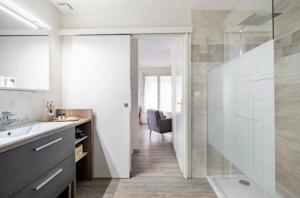 a bathroom with a sink and a glass shower at Le chalet de la prairie in Beaucroissant