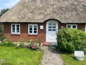 a small brick house with a thatch roof at Deichbrise in Aventoft