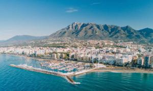 an aerial view of a beach with buildings and a mountain at SuperHosts Suites Estepona in Estepona