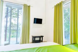 ein Schlafzimmer mit gelben Vorhängen, einem Bett und einem Fenster in der Unterkunft Hungili Farm & Eco Resort in Maho