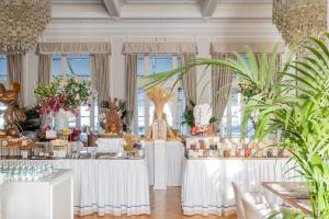 a large room with white tables and plants at Grand Hotel Principe Di Piemonte in Viareggio