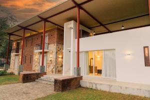 ein Backsteinhaus mit einer weißen Fassade und einem Fenster in der Unterkunft Hungili Farm & Eco Resort in Maho + 5 Fotos