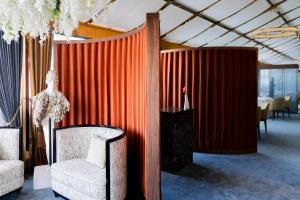 a red curtain in a room with a chair and a table at Grand Hotel Principe Di Piemonte in Viareggio