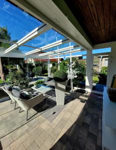 a patio with couches and a table and chairs at Ferienhaus Grüner Bungalow Kontaktloser CheckIn in Stendell
